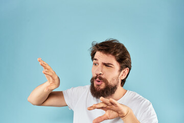 Emotional man with a beard in a white t-shirt blue background fun lifestyle