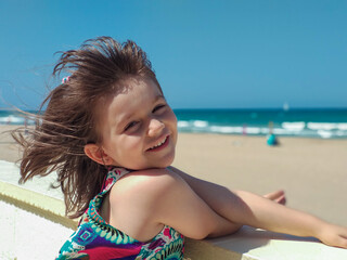 Girl looking at the beach from the promenade