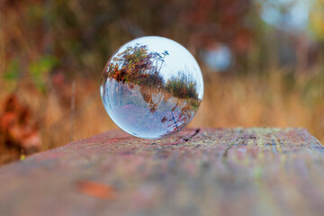 Landscape photographed through a glass sphere. There is a reflection of the landscape in a glass sphere.