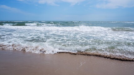 Clear sea water, wave and sand beach.