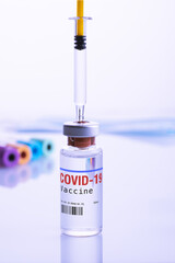 Close up of a vial of Covid-19 Vaccine and a srynge on laboratory background. Copy space