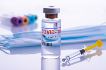 Close up of a vial of Covid-19 Vaccine and a srynge on laboratory background.
