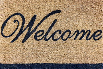 Welcome written on the rug at the entrance door.