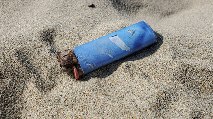 Salt rust Corroded Plastic lighter discarded on sandy sea ecosystem,microplastics sea coast pollution 