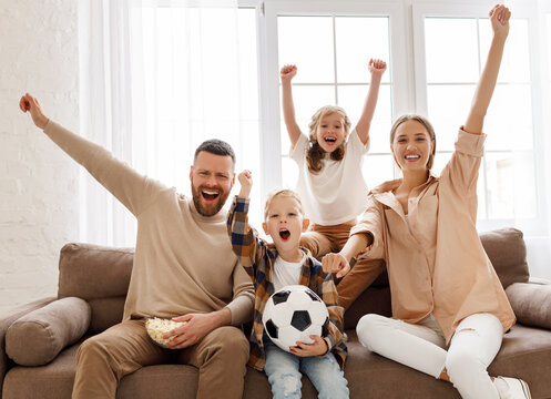 Excited Family Watching Football At Home