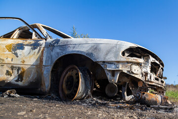 Burned down car, abstract background, selective focus. The situation of protests in the world.
