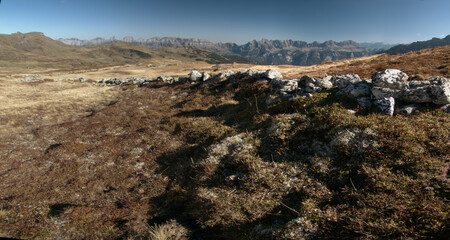 Stone wall and view from Maschgenkamm towards the Churfirsten, Flumserberg in the Swiss Alps