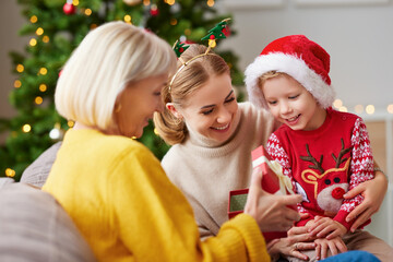 Cheerful relatives opening gifts on Christmas day.