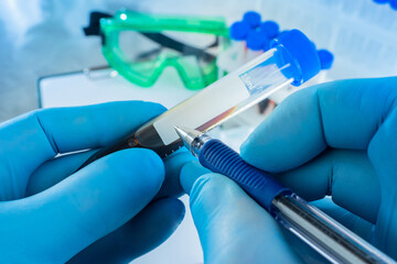 Man signs a test tube with blood. Test tube in hands of doctor. Hands with a blood sample close up....