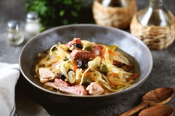 Traditional Russian soup Solyanka with smoked ribs, pork, cabbage, olives and capers.