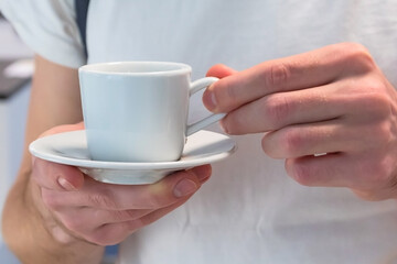 white coffee mug in men's hands
