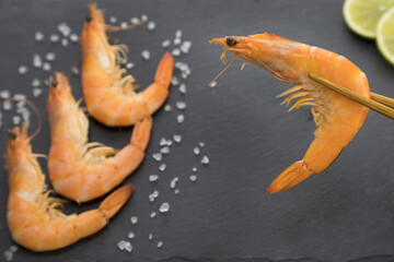 Shrimp on a plate with lime and chopsticks