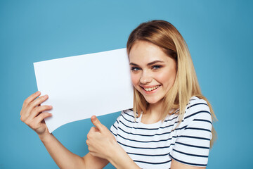Woman holding sheet of paper striped T-shirt Copy Space cropped view blue background