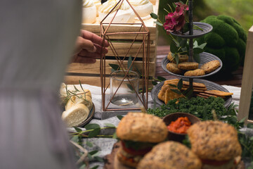 Anonymous female hands setting up a table for a garden party.