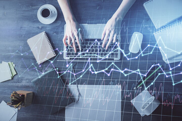 Multi exposure of woman hands working on computer and forex chart hologram drawing. Top View. Financial analysis concept.