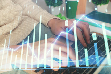Double exposure of woman hands typing on computer and forex chart hologram drawing. Stock market...