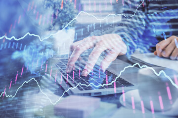 Double exposure of woman hands typing on computer and forex chart hologram drawing. Stock market invest concept.