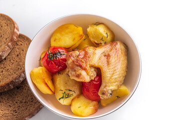 Fresh Baked potatoes with chicken pieces tomatoes on a plate