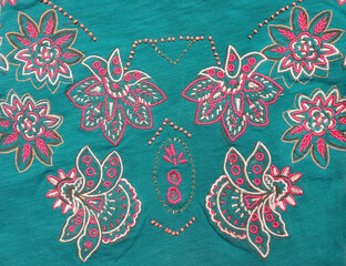 Floral embroidery decoration on teal cotton fabric