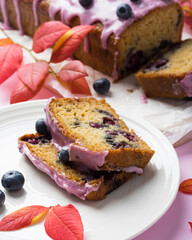 Homemade blueberry cake with pink frosting decorated with berries. Autumn treat for tea time