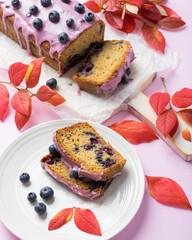 Homemade blueberry cake with pink frosting decorated with berries. Autumn treat for tea time