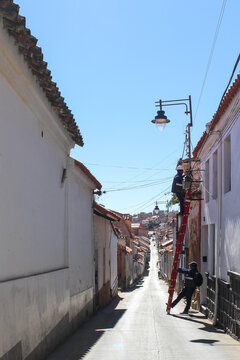 View Of Classic Colonial Street With Cable Workers At Sucre White City In Bolivia