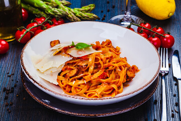 Pasta with seafood, tomato and parmesan cheese on white  plate