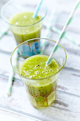 Green smoothie topped with chia seeds on bright wooden background. Close up.	
