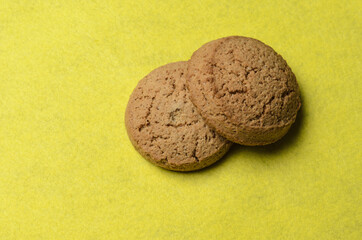 Oatmeal cookies on a blurry yellow background.