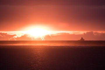 sunset over the sea with silhouette of a boat