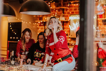Fototapeta na wymiar blonde woman sitting with a glass of champagne on a Christmas kitchen island