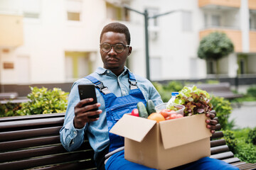 Young Afro-American or African male working in everyday or daily home delivery service.