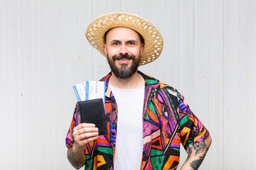 bald man smiling happily with a hand on hip and confident, positive, proud and friendly attitude