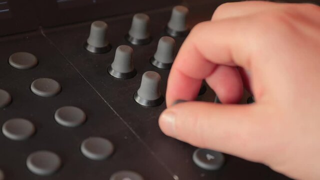 Turning knobs on a mixer board, or computer contol surface studio mixing desk panel, digital audio equipment