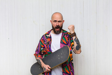 bald man shouting aggressively with an angry expression or with fists clenched celebrating success