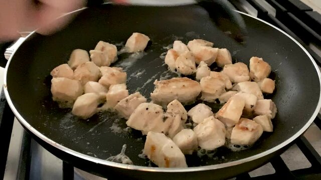 Slo motion of Cooking Diced Chicken Pieces in a Frying Pan