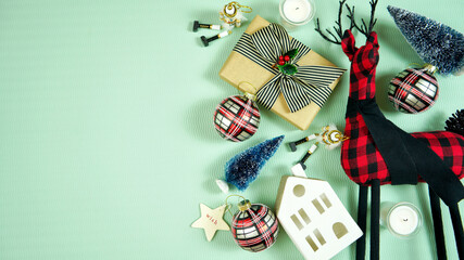 Modern Christmas gift wrapping scene with buffalo plaid farmhouse style reindeer and decorations. op view blog hero header creative composition flat lay. Negative copy space.