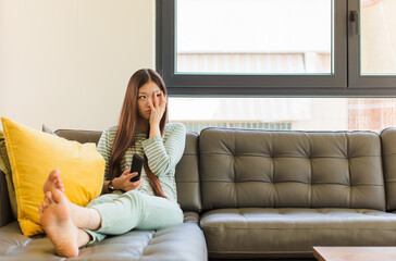 young asian woman feeling bored, frustrated and sleepy after a tiresome, dull and tedious task,...