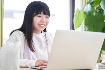 リビングでパソコンを操作する日本人女子中学生
