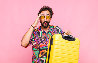 young bearded man looking happy, astonished and surprised, smiling and realizing amazing and...