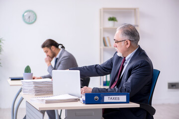 Old boss and his young assistant working in the office