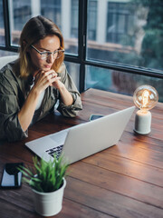 Woman working on laptop. Freelancer at remote work. Female student learning on-line via computer. Blogger or journalist writing new article.