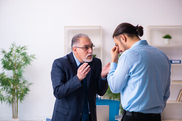 Old boss and his young assistant in the office