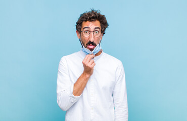 young bearded man feeling disgusted and irritated, sticking tongue out, disliking something nasty...