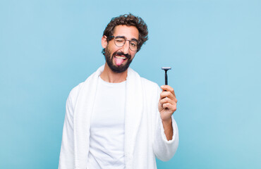 young bearded man with cheerful, carefree, rebellious attitude, joking and sticking tongue out,...
