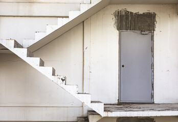 Front shot of abandoned building and apartment in urban city shows grunge staircase and door for fire escape which is beautiful art and abstract of unfinished and empty construction architecture
