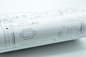 Detalle de un plano arquitectónico enrollado sobre fondo blanco