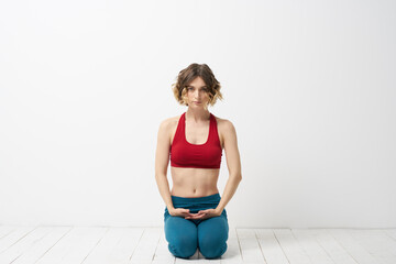 the girl is engaged in yoga on a light background Red T-shirt gesticulating with his hands