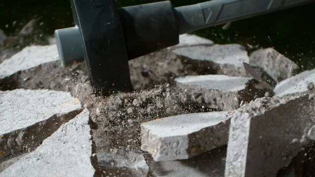 Super slow motion of detail of sledgehammer hitting concrete brick. Filmed on very high speed cinema camera, 1000 fps.