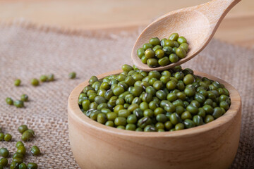 Green beans seed or Green nuts seed  in wooden spoon and a bowl on on a wooden table top view, Close-up and macro shot, Organic food from nature concept.